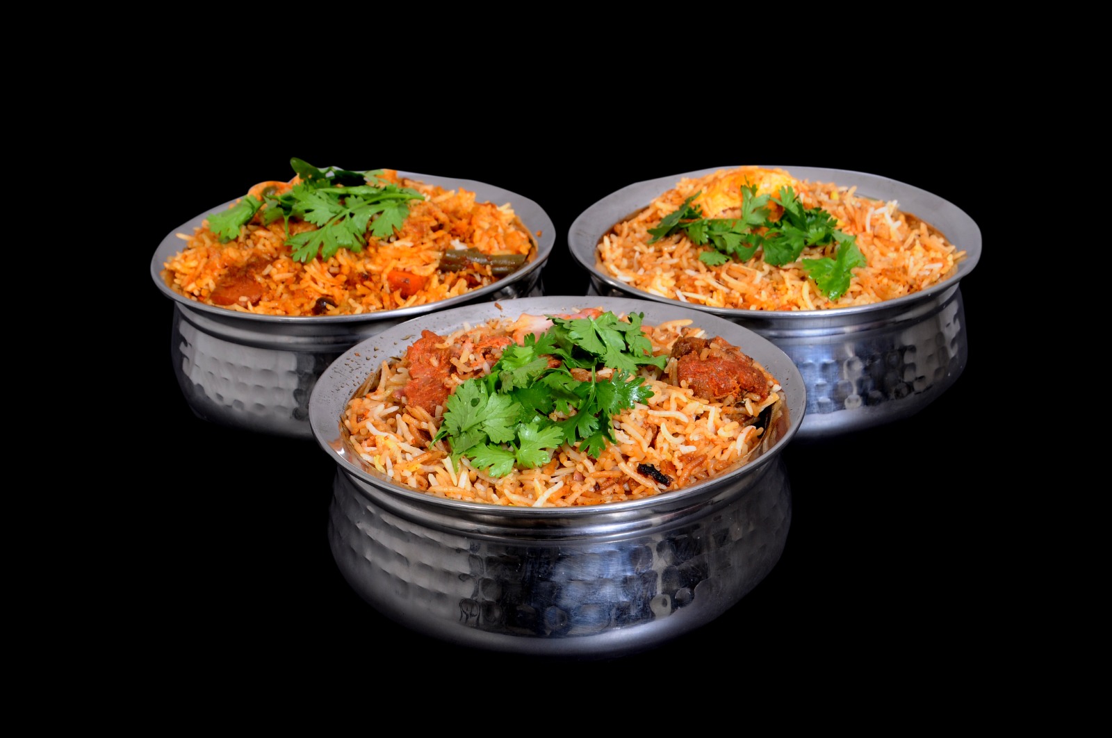 Three handis of Hyderabadi Dum Biryani &mdash; mutton, chicken and veg &mdash; topped with fried onions and fresh coriander